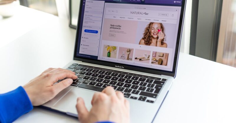 Como escolher a melhor plataforma digital para vender online Pessoa usando laptop em mesa com site de beleza aberto na tela.